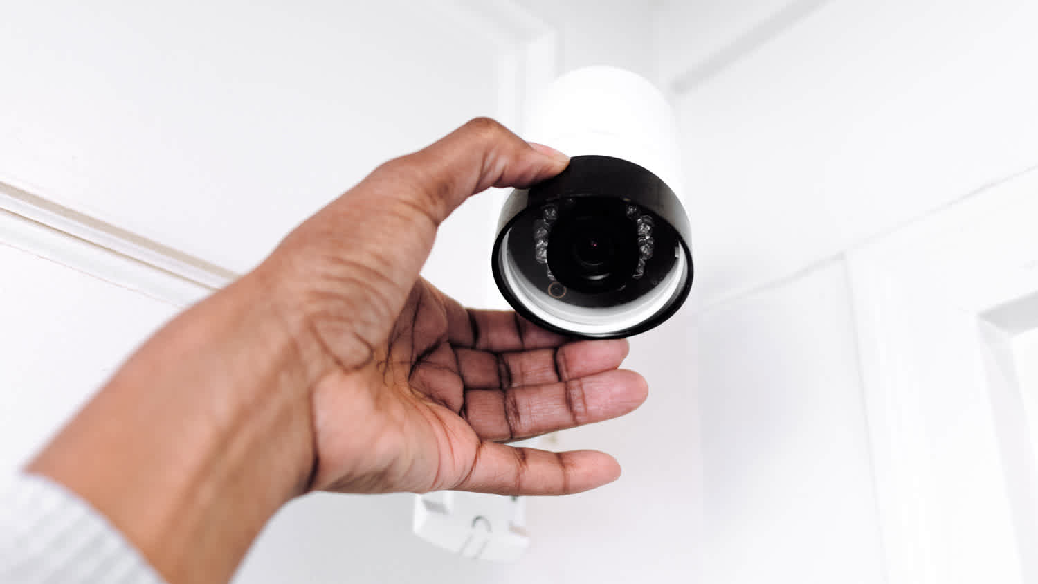 A woman adjusting a wireless monitoring camera