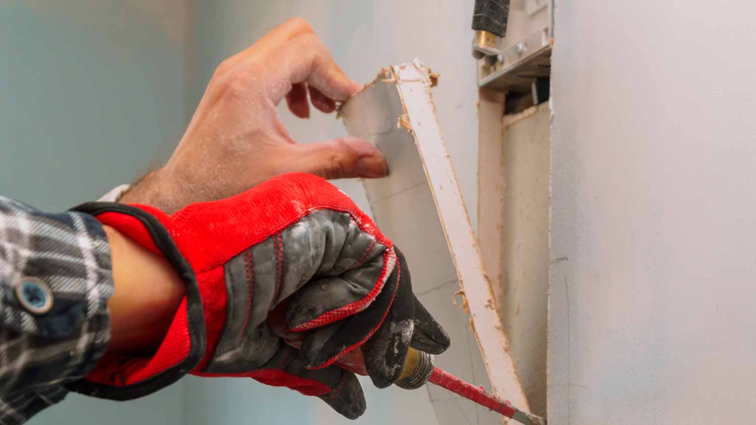 Man cutting hole in the wall