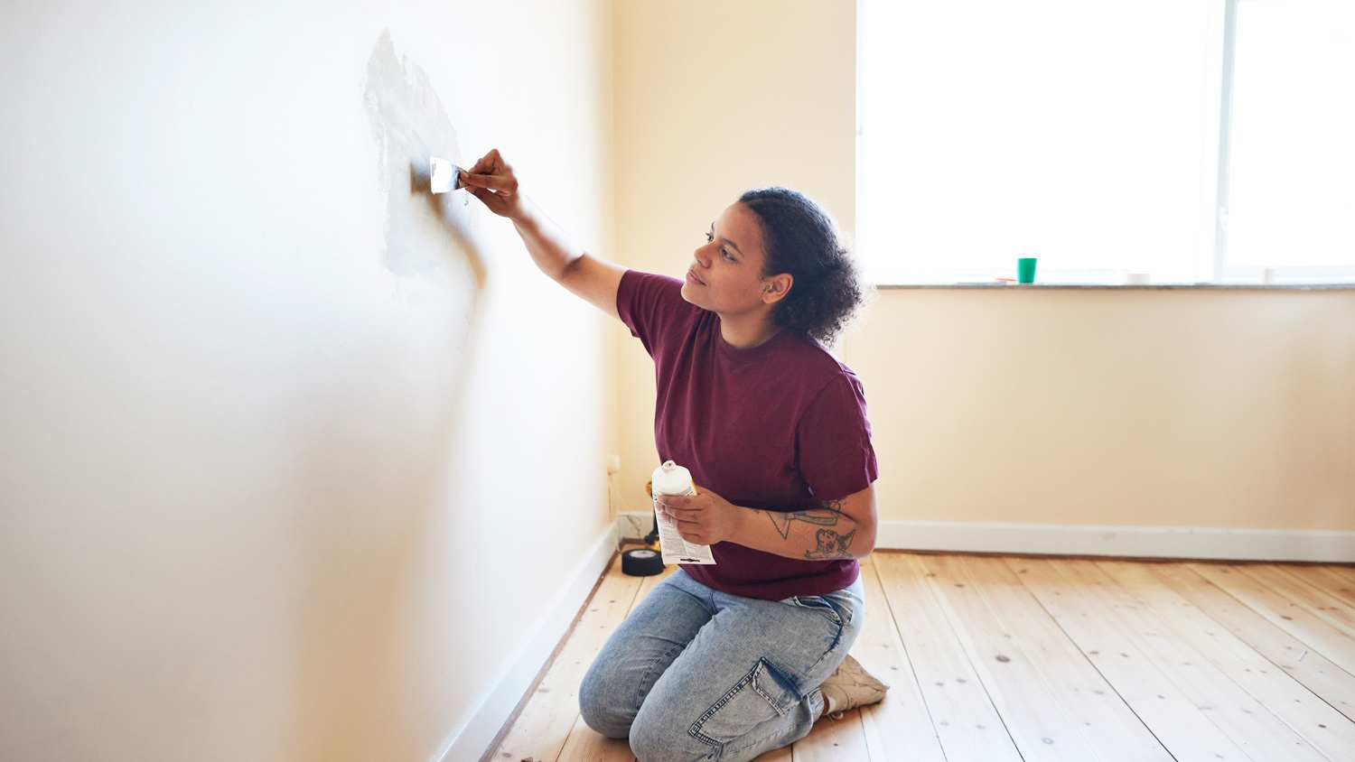 Woman finishing wall while renovating home