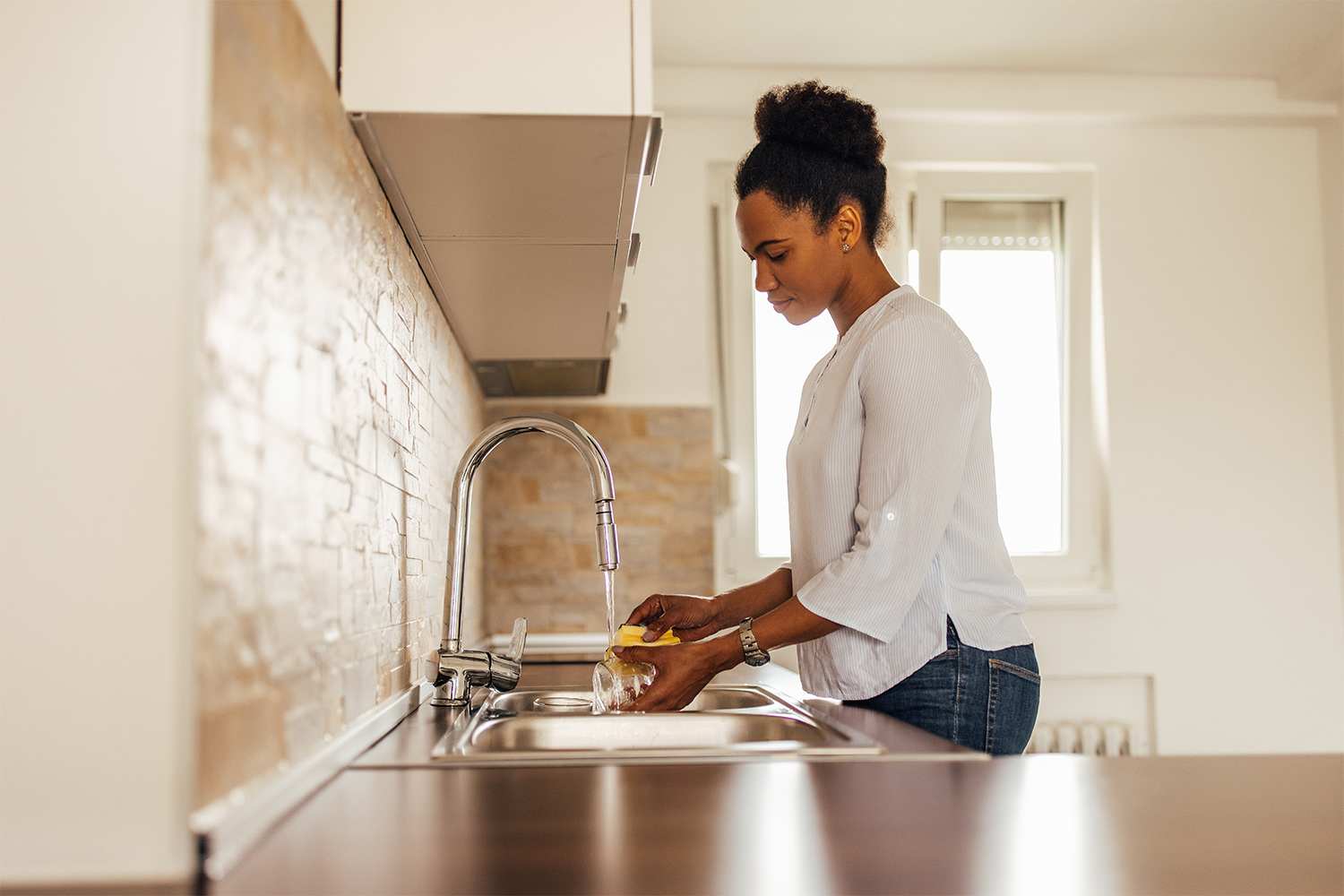 Woman washing dishes in sink