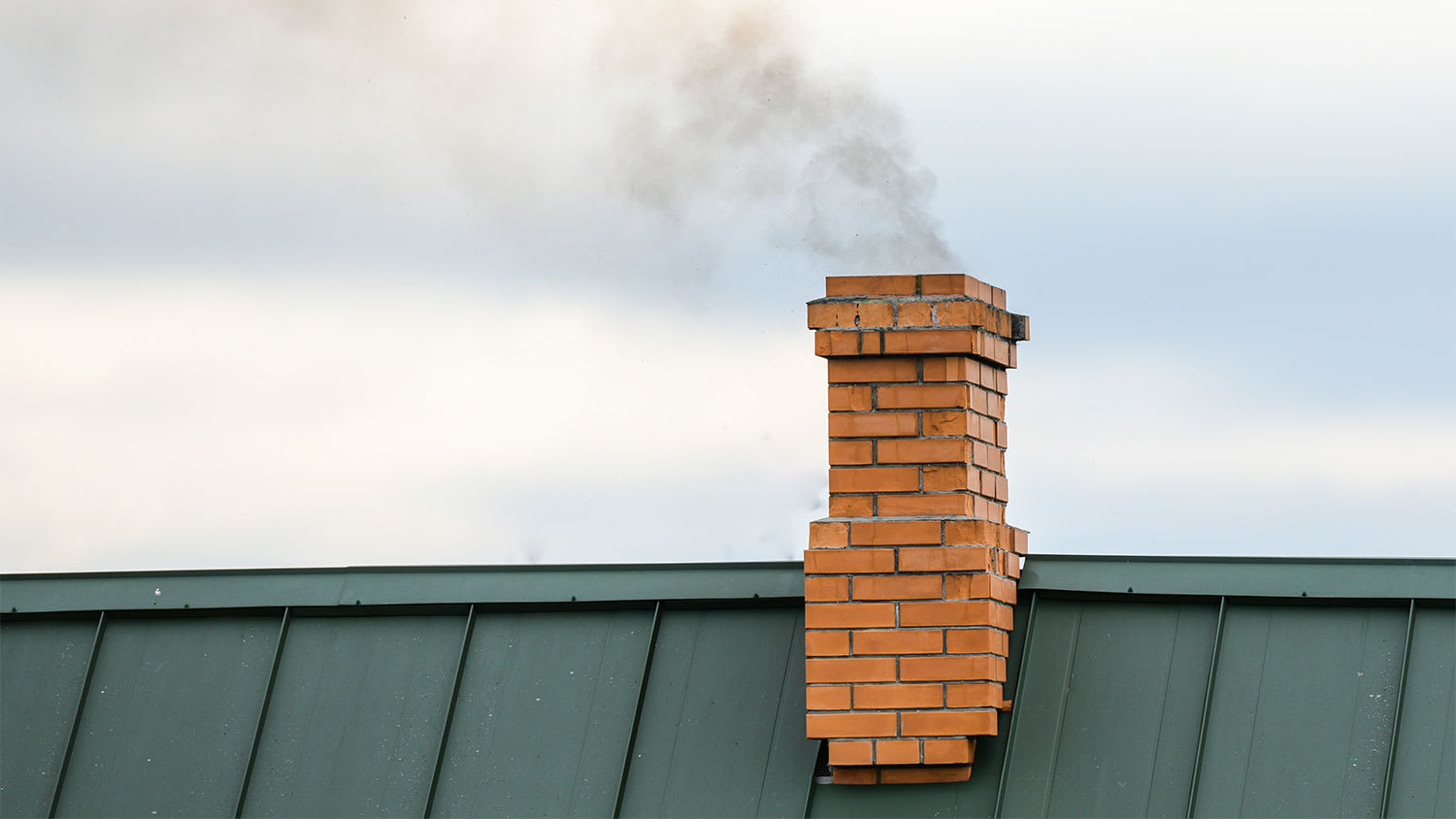 Smoke coming out of house chimney
