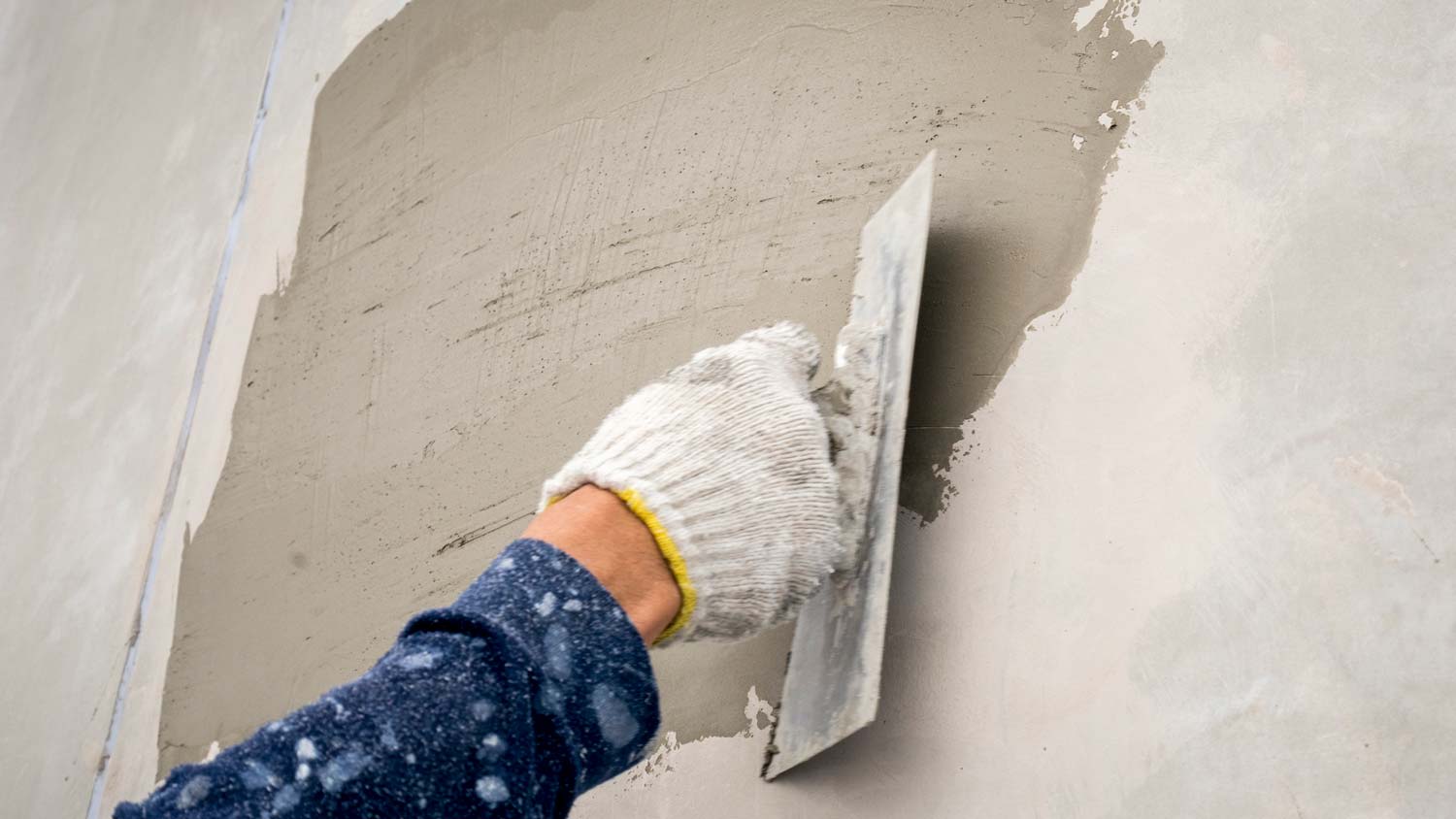 A person applying plaster on wall