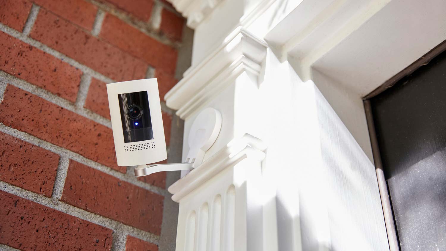 A security camera in the exterior of a red brick house