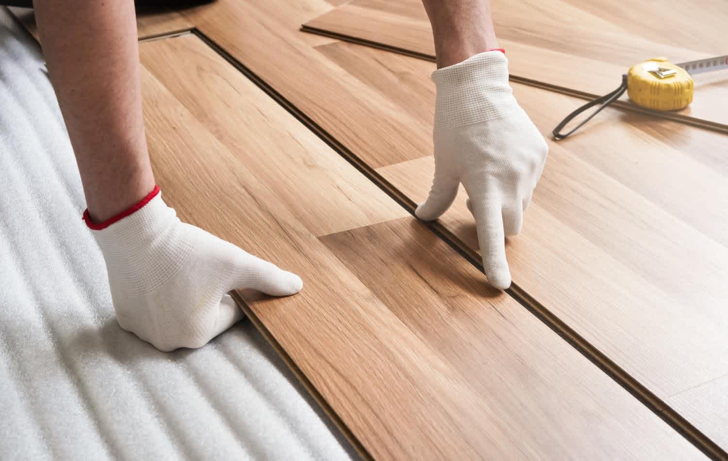 A man Installing laminate floor on the kitchen