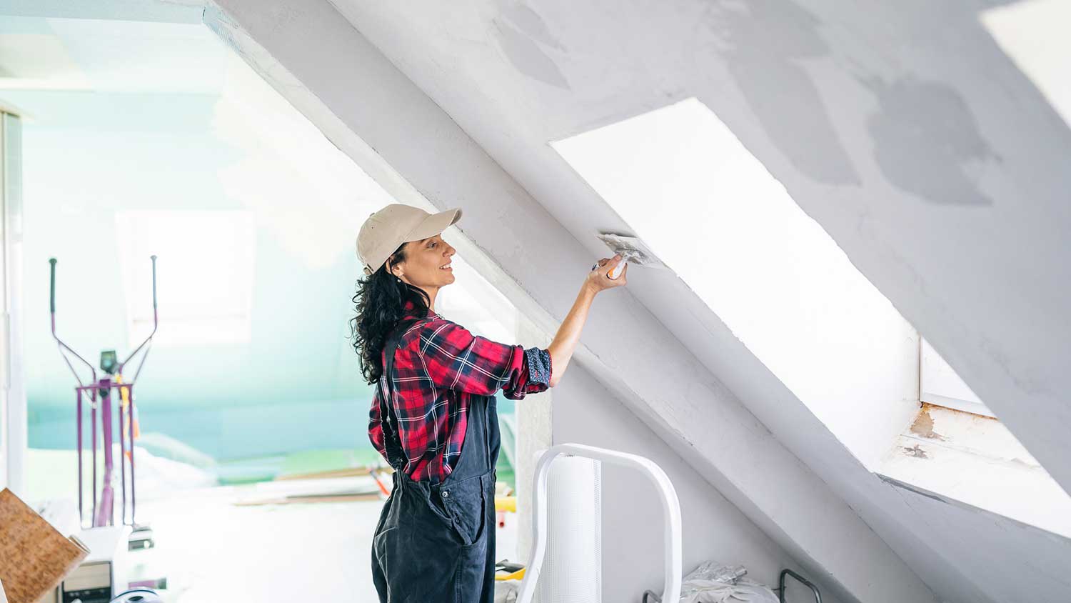 Woman using trowel to repair the attic ceiling