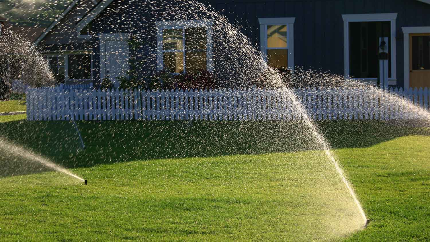 Sprinklers operating in the front yard of a house