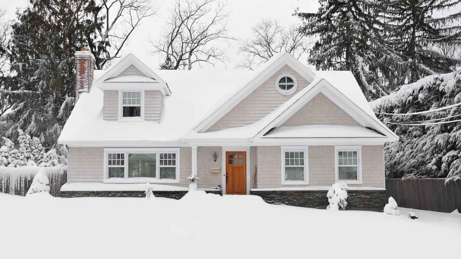 A two-story house covered in snow