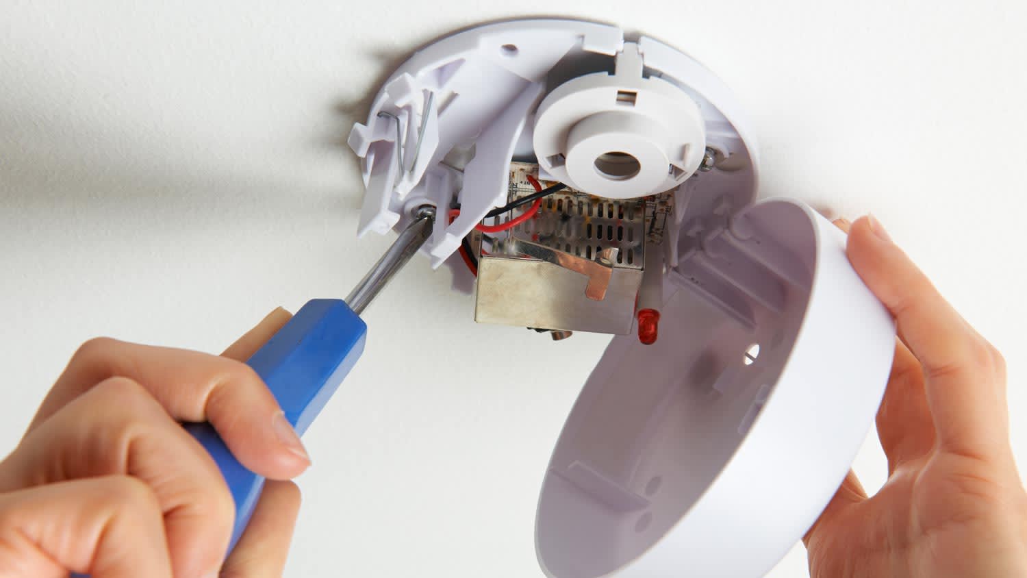man wiring smoke detector