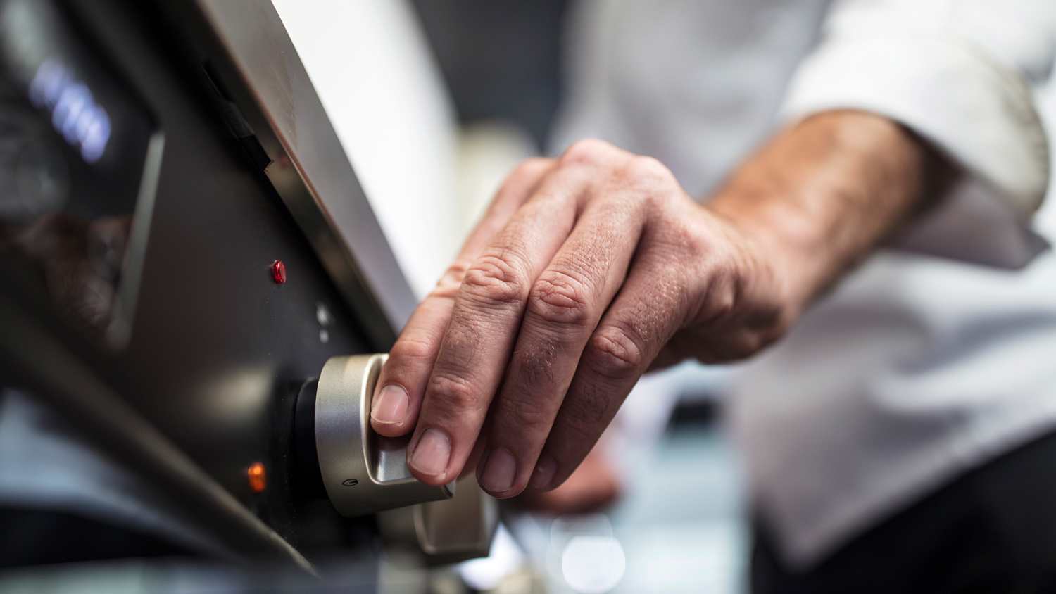 Chef turning on oven, close-up