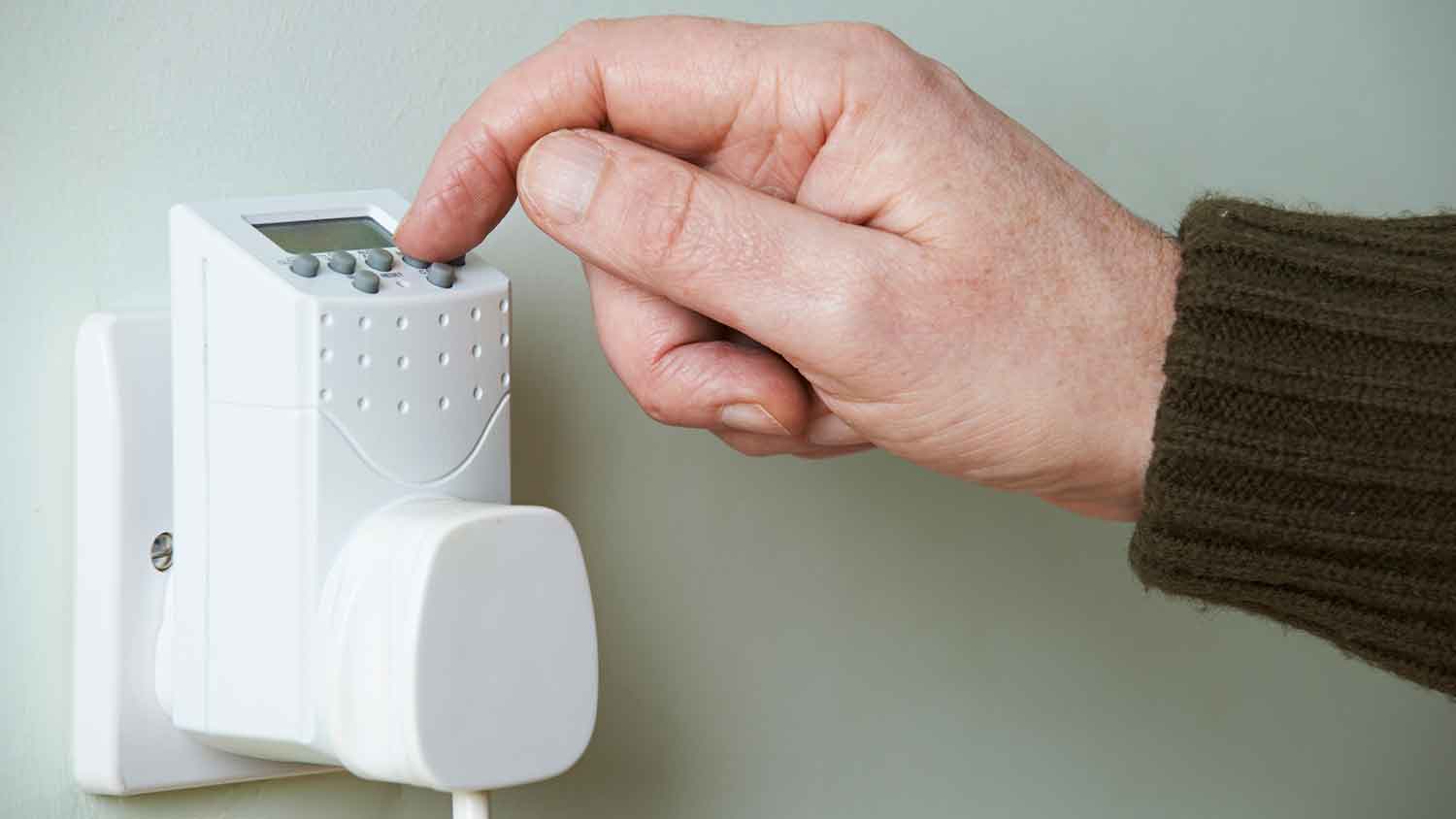 Hand setting digital light timer plugged to the wall