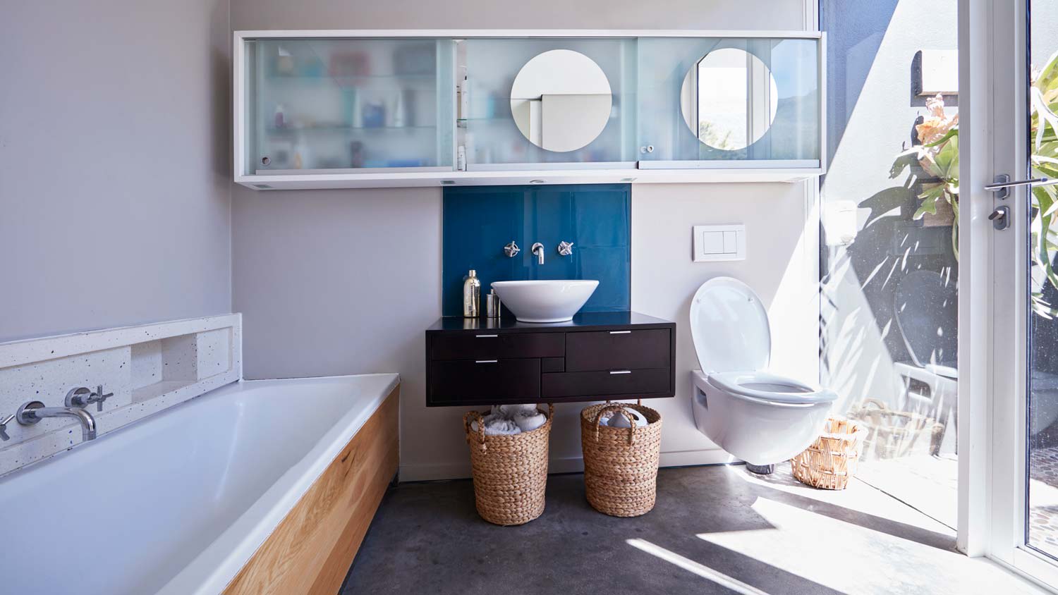 A sunny bathroom with a toilet and a bathtub
