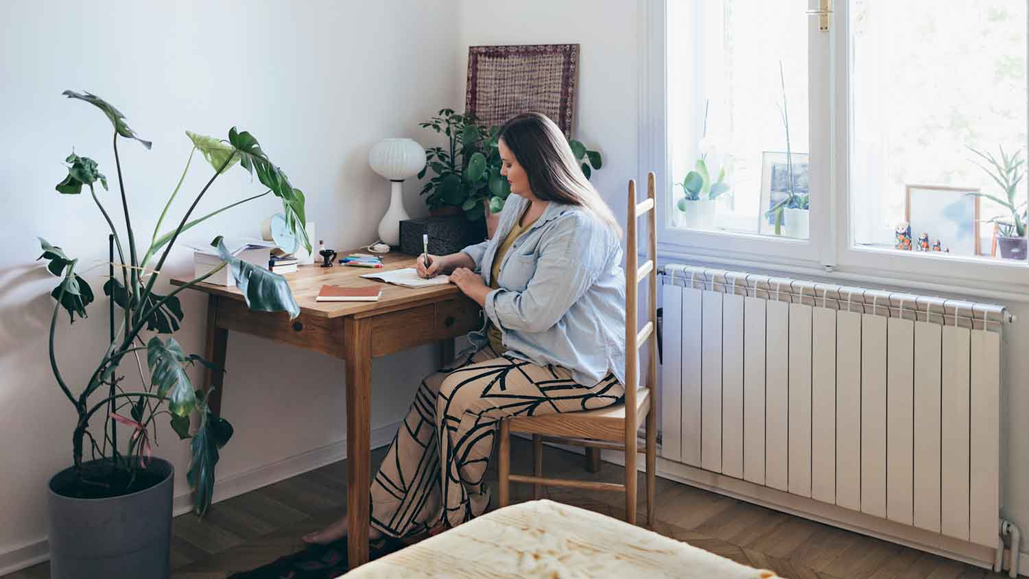 Woman sitting at her desk in her room taking notes