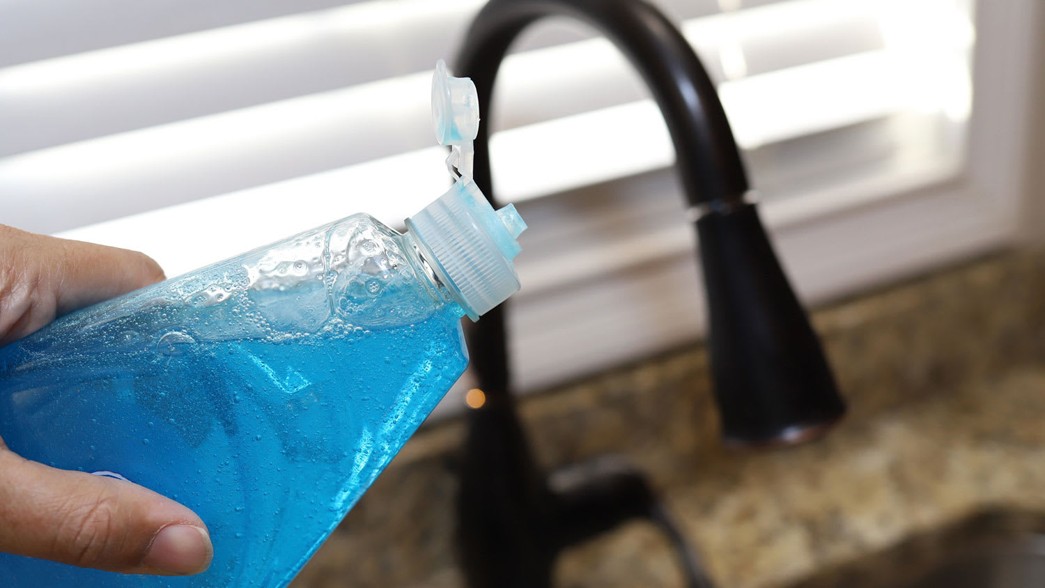 hand holding dish soap bottle