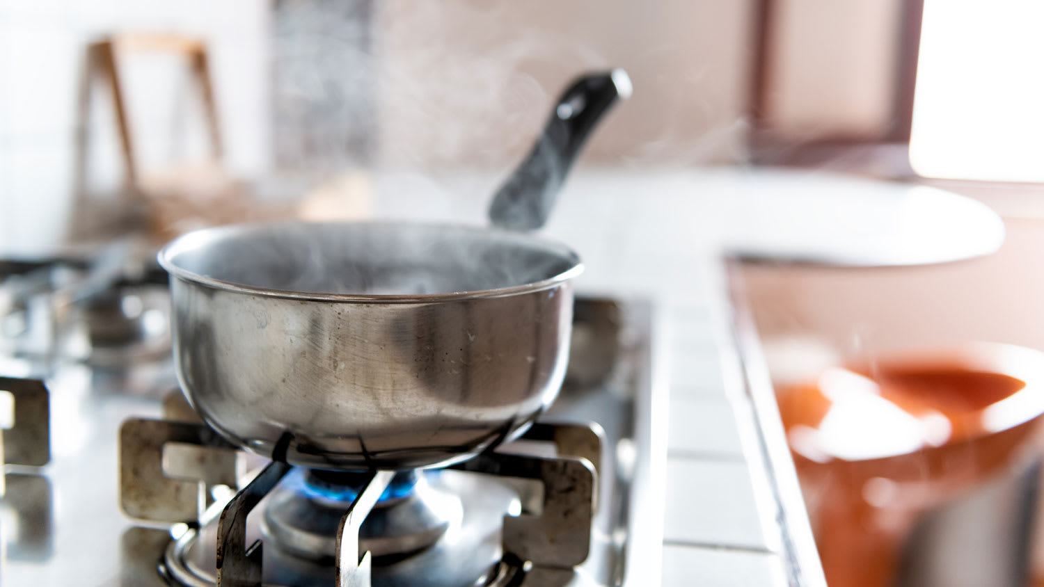 Saucepan with boiling water on top of gas stove