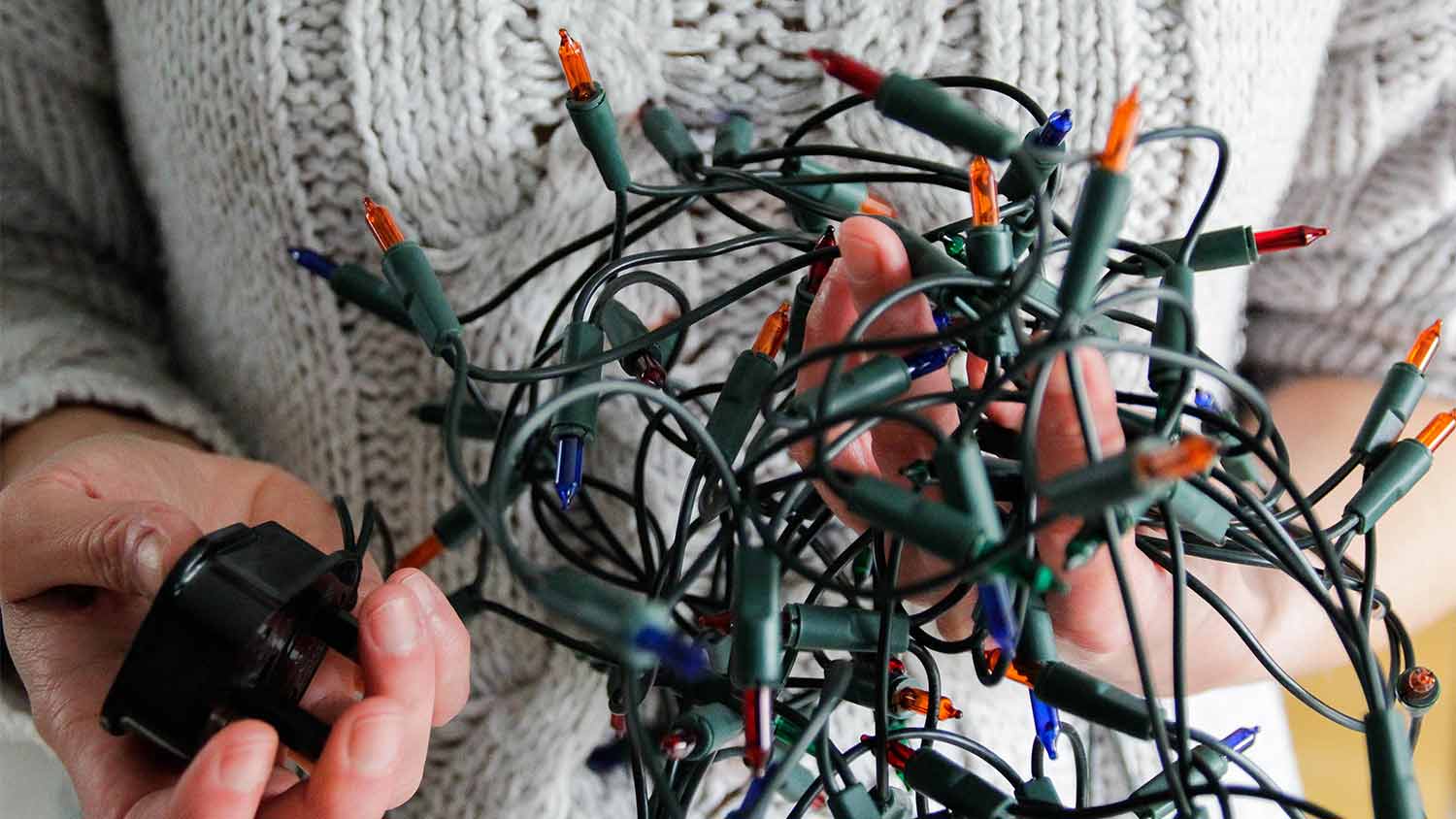 woman holding colorful christmas lights