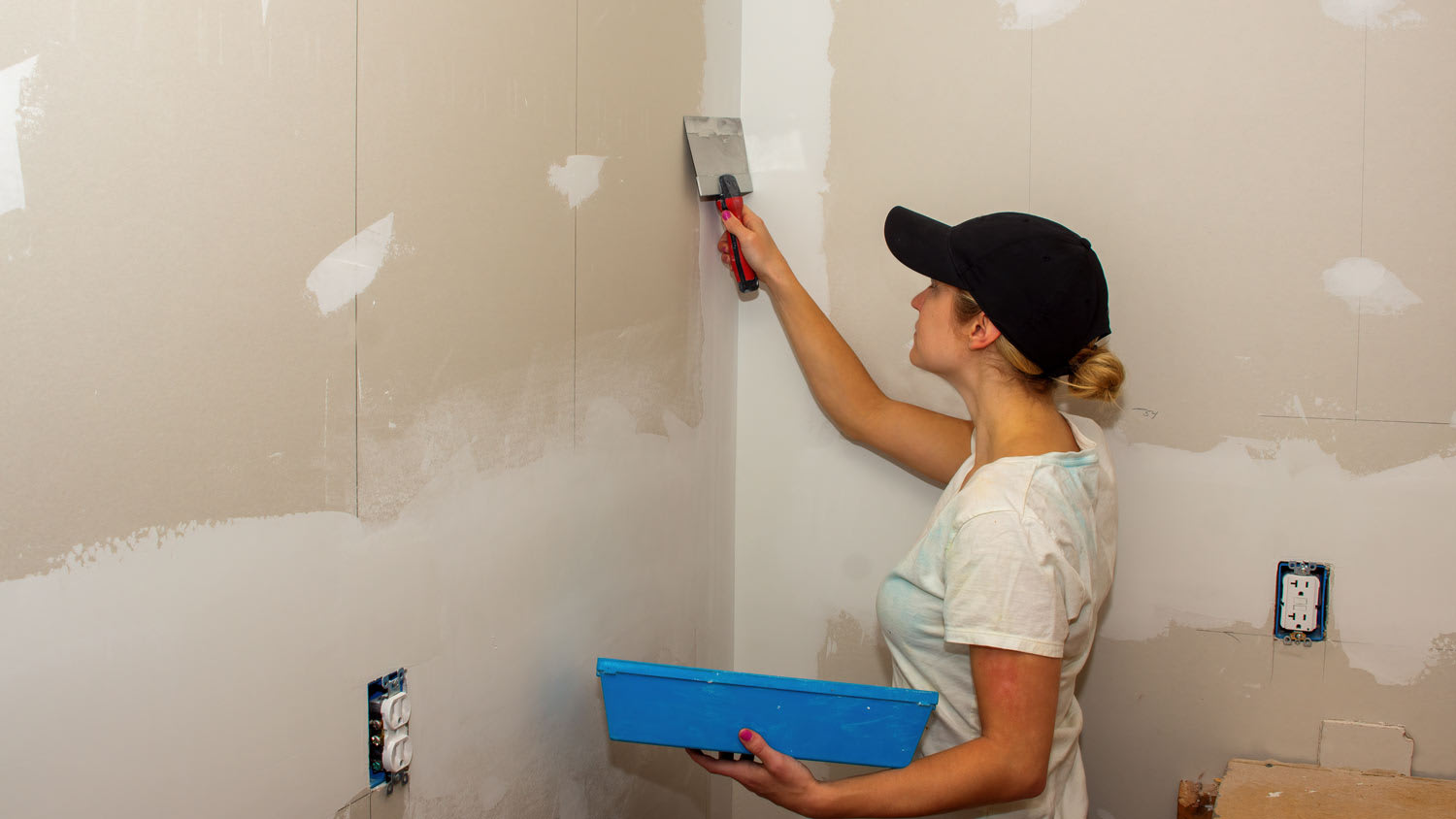 woman plastering a corner of the way