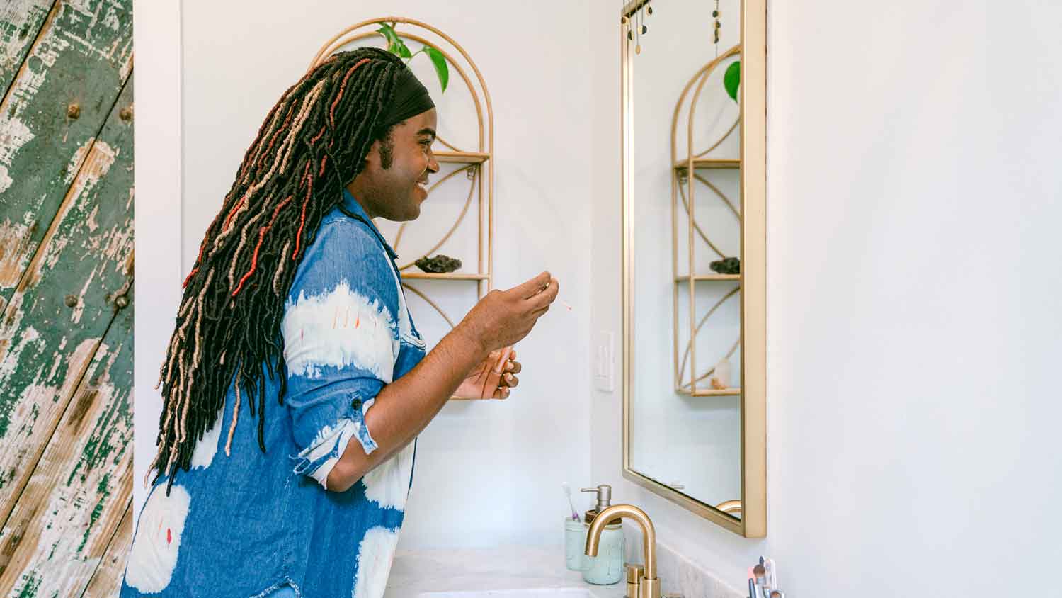 Woman looking in the mirror and applying makeup