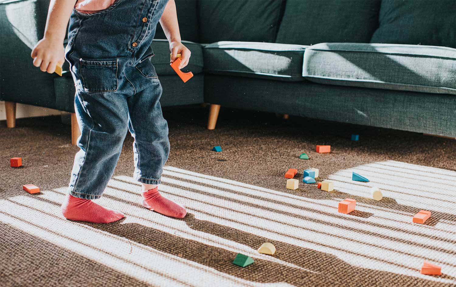 Child playing with toys on living room carpet