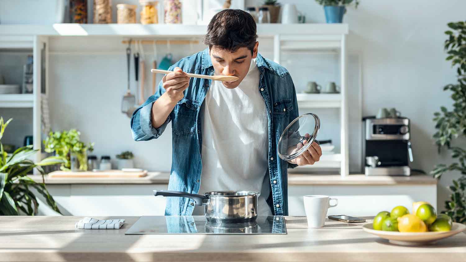 Man tasting and cooking supper on the stove