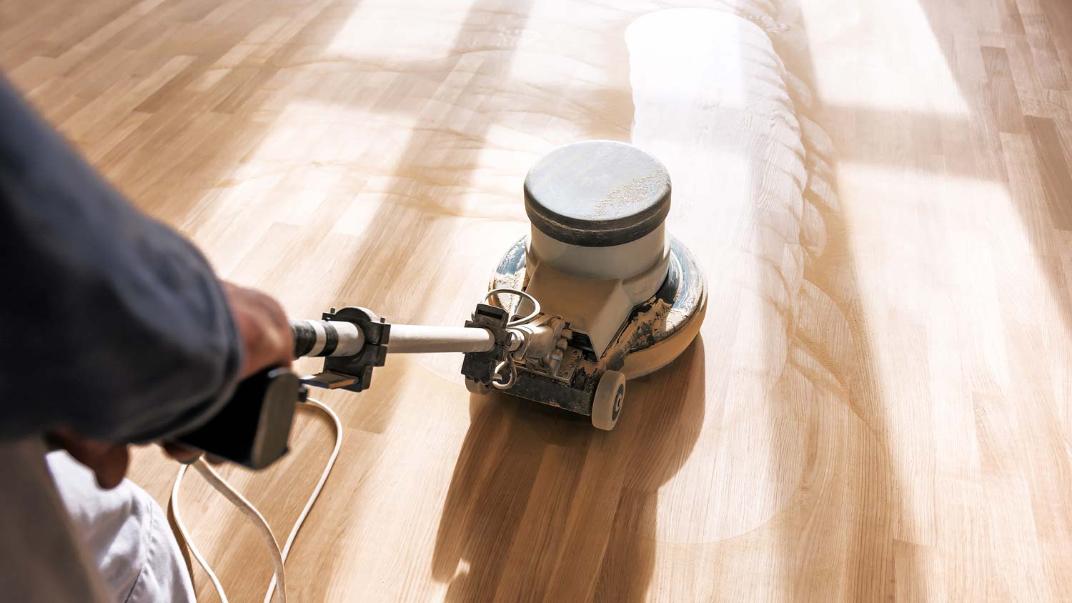 A man sanding hardwood floor