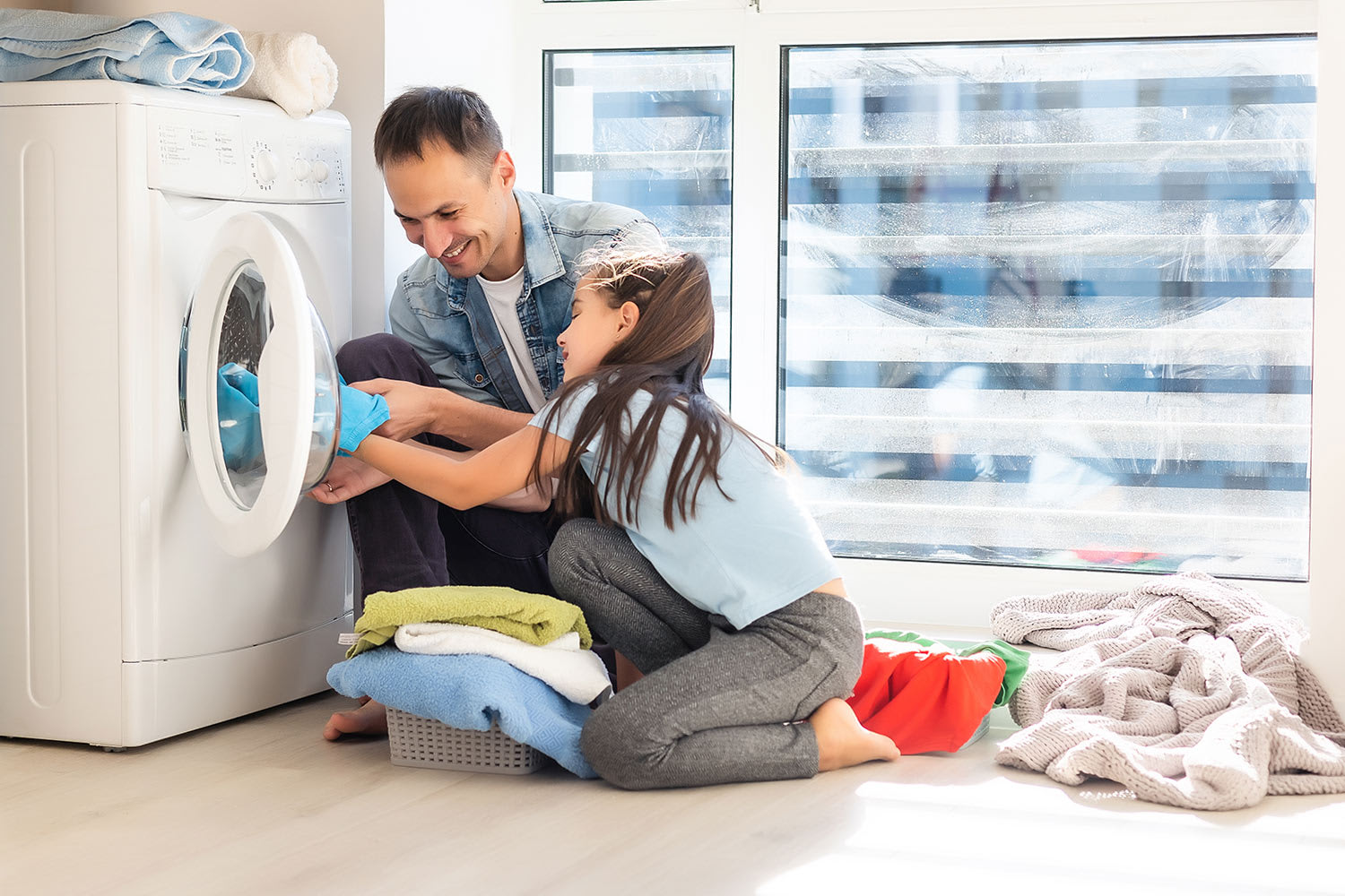 father daughter doing laundry at home