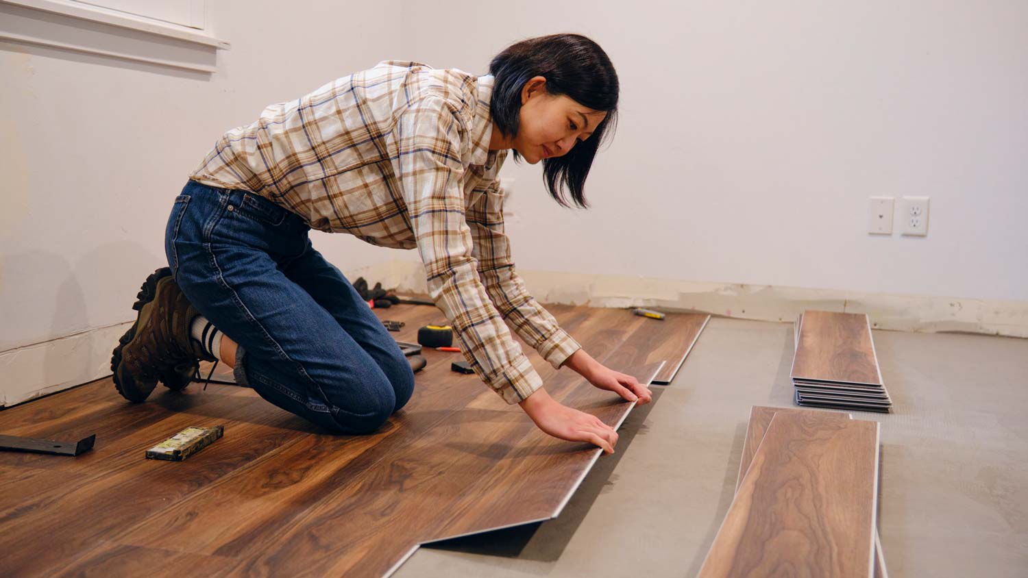 A woman installing a laminate floor