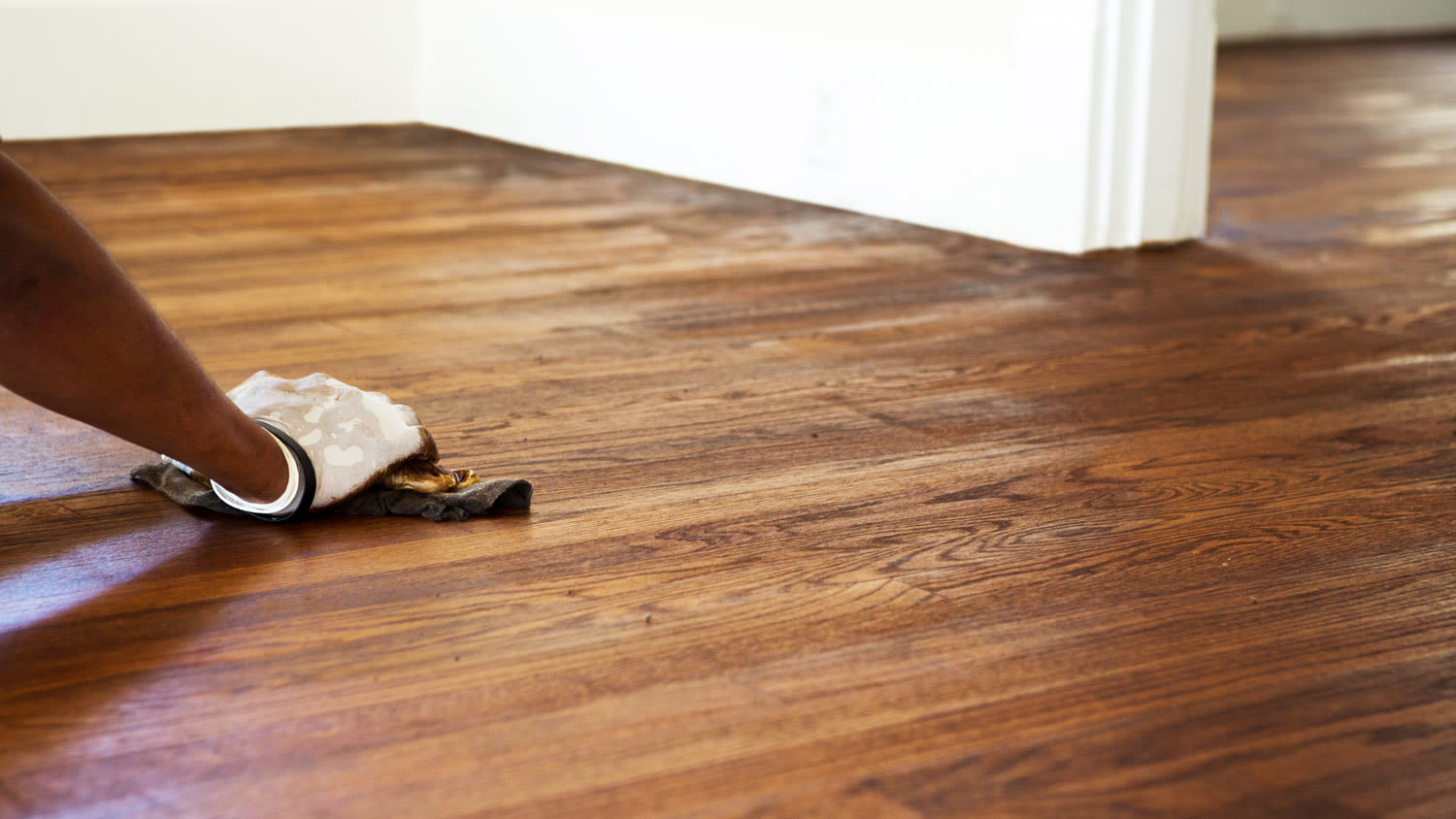 Close-up of hand refinishing a floor