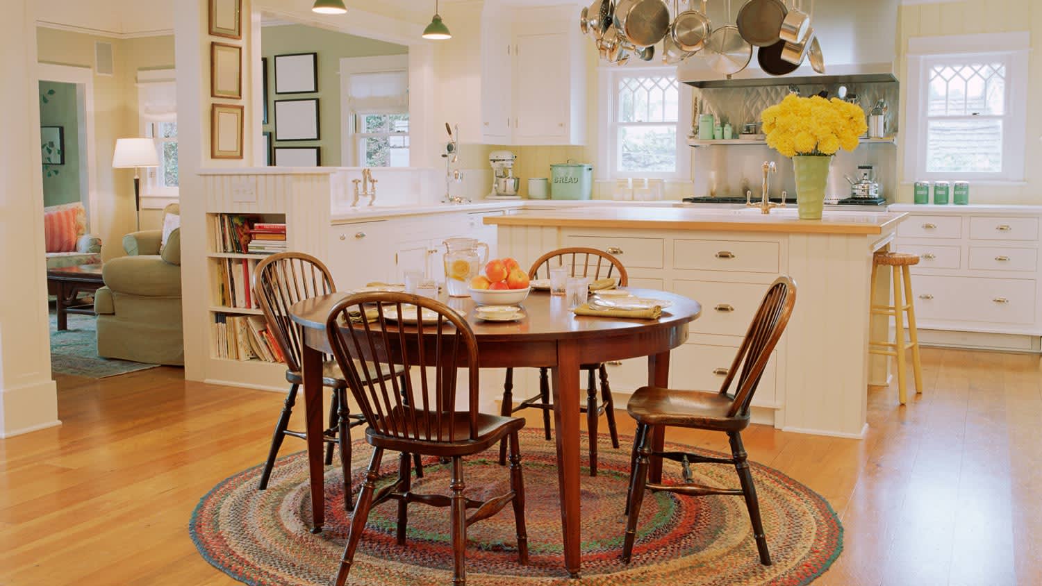 A traditional kitchen with wooden table, chairs and hardwood floor