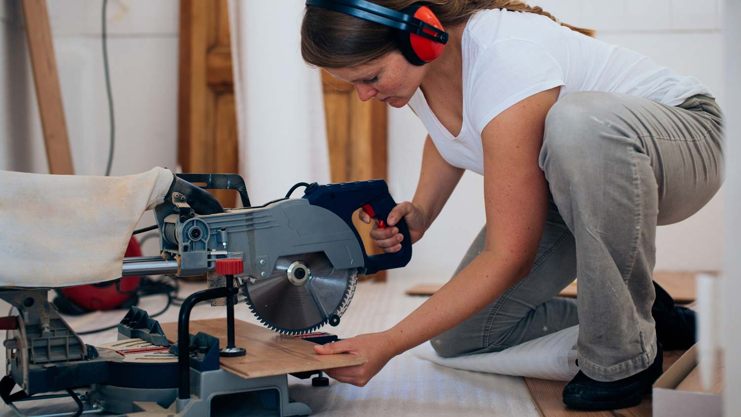 A woman cutting a laminate plank