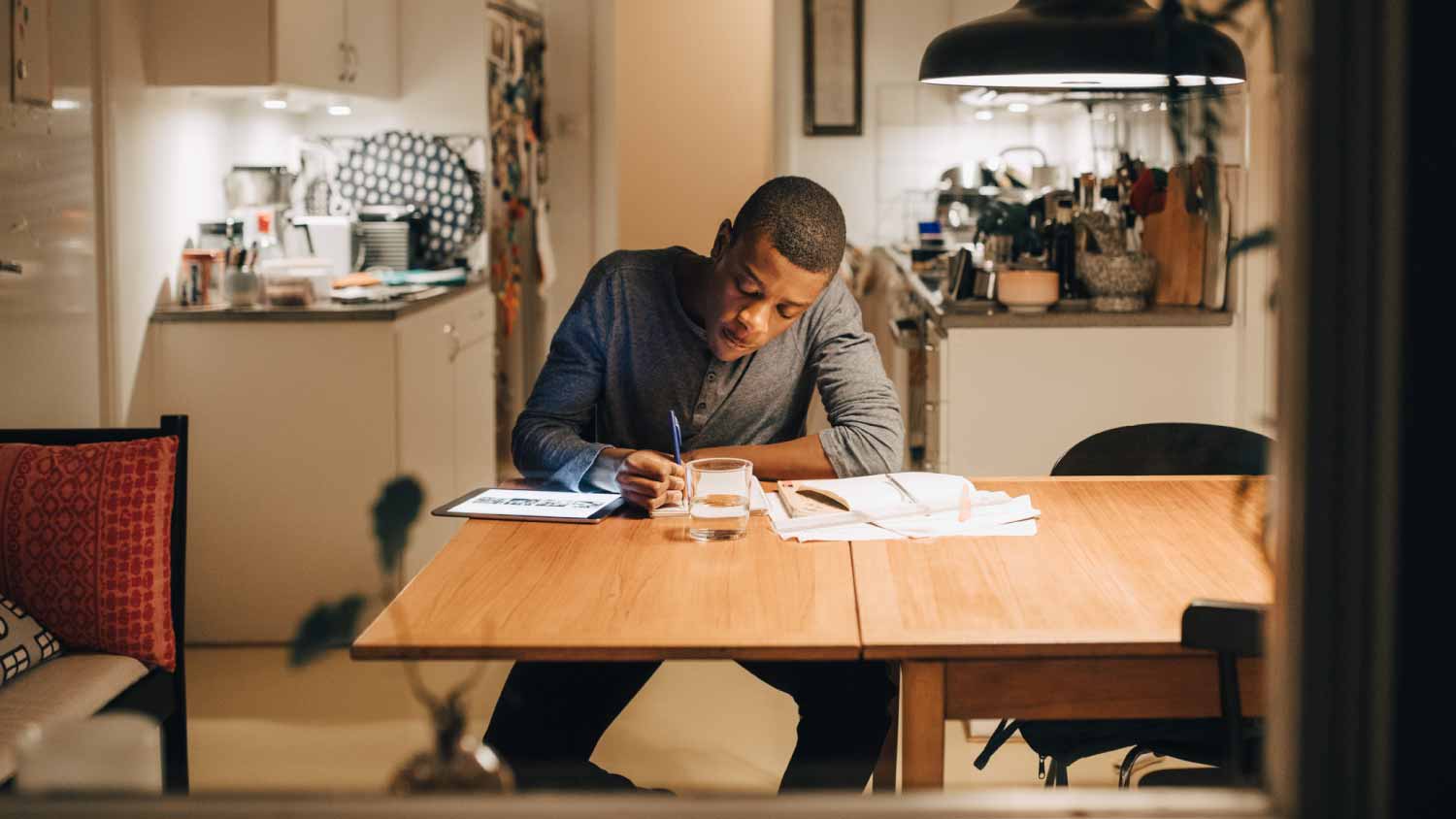 Boy writing homework on table