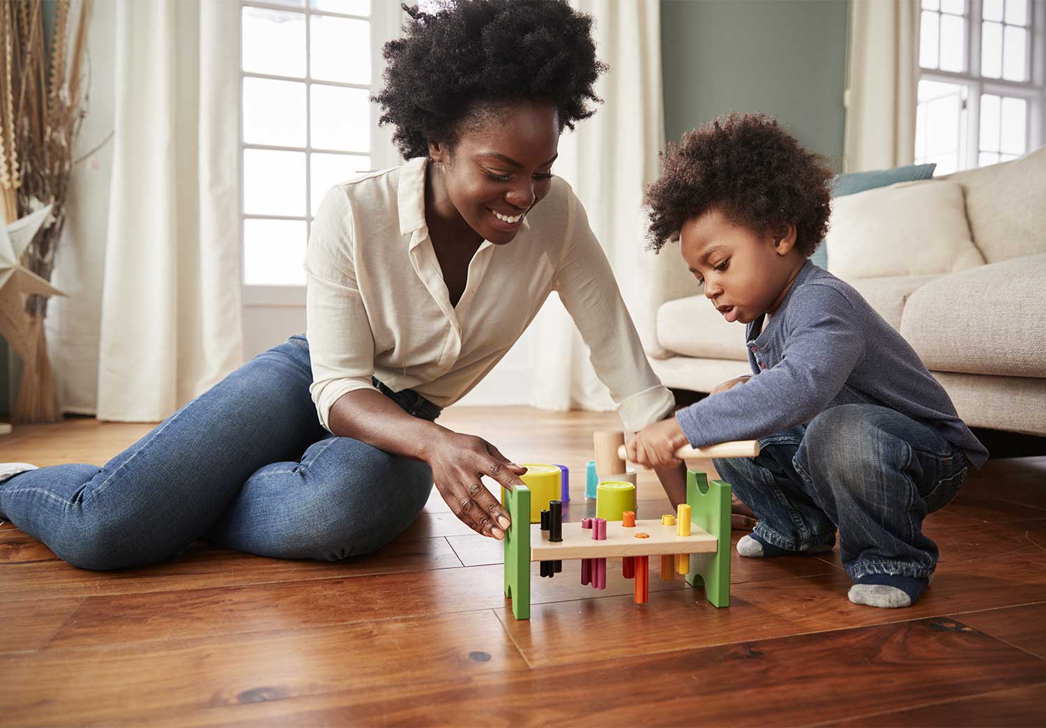 Mother and son sitting on the floor playing together