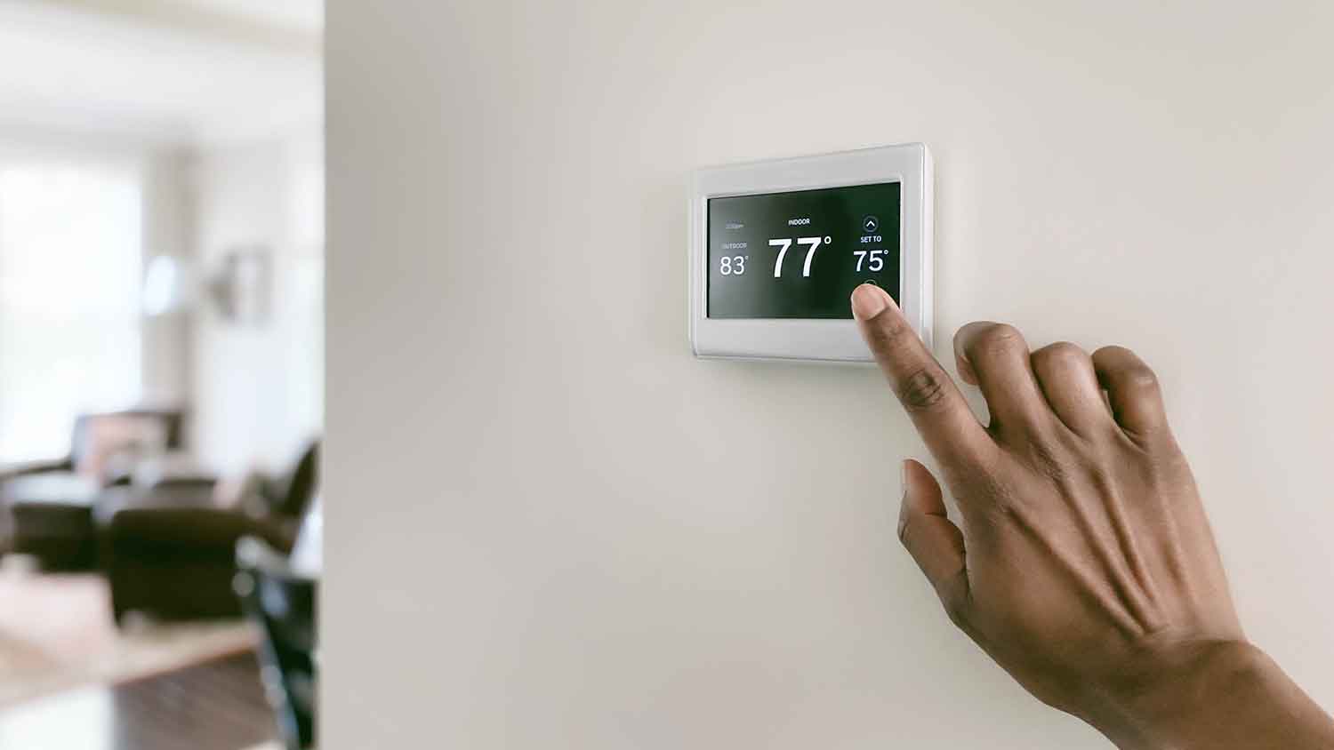 Adjusting digital thermostat in the hallway