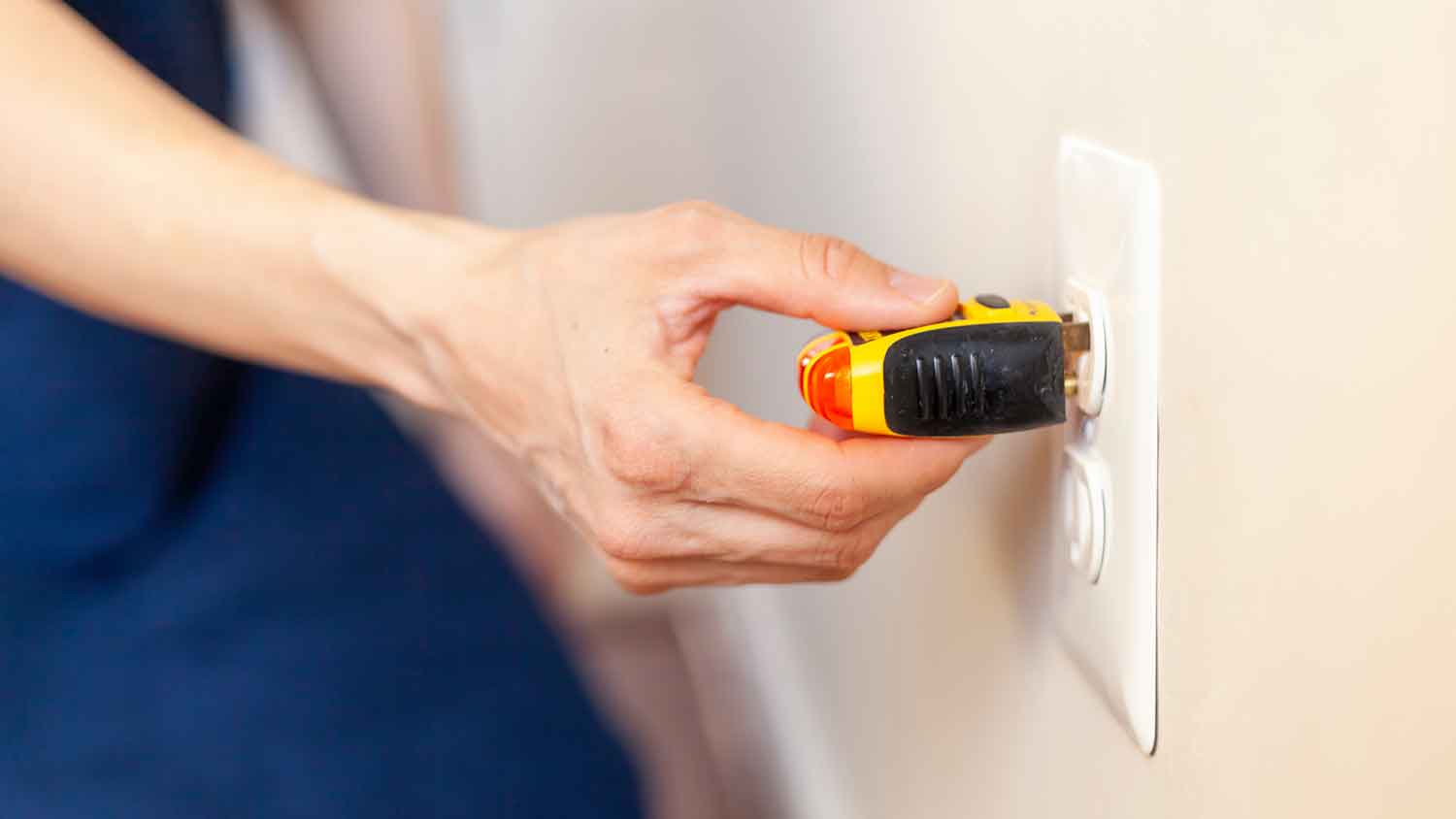 Woman testing outlet voltage