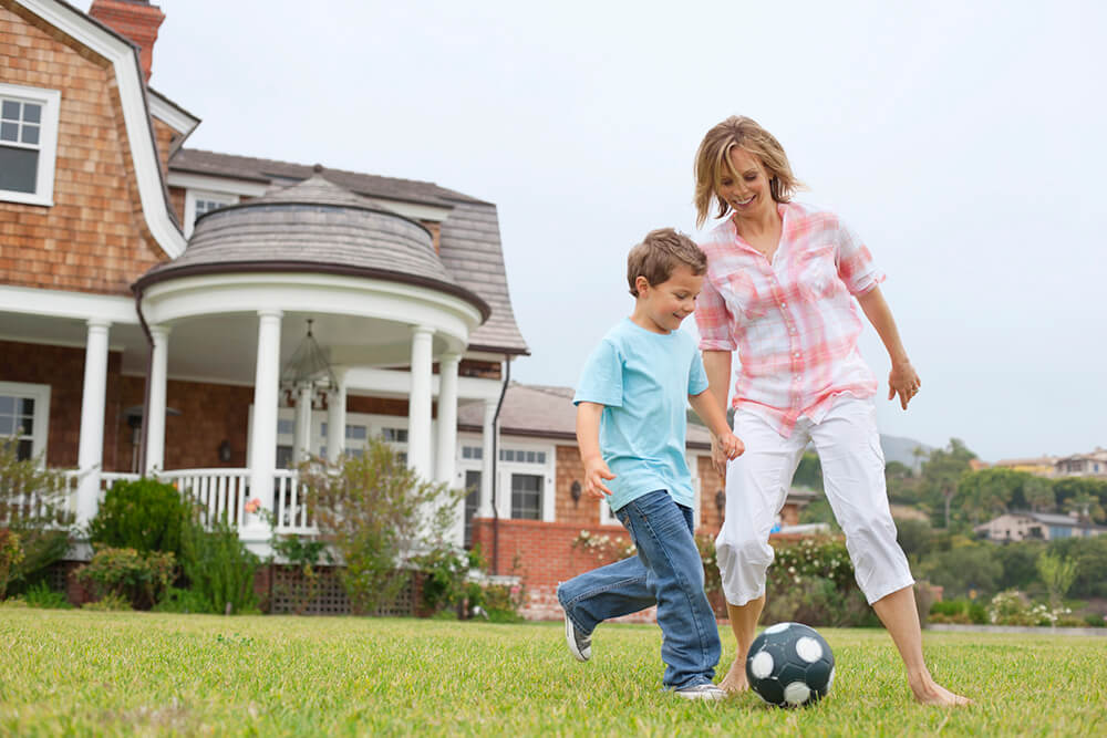Family playing with a ball with a house in the background
