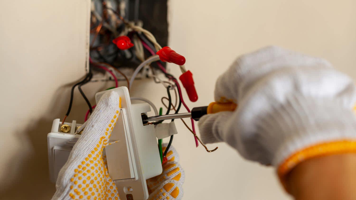 A person installing a new wall switch
