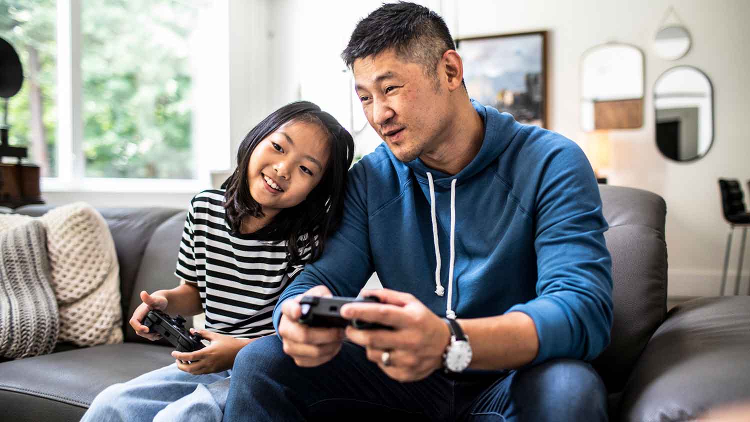 Father and daughter playing video games at home