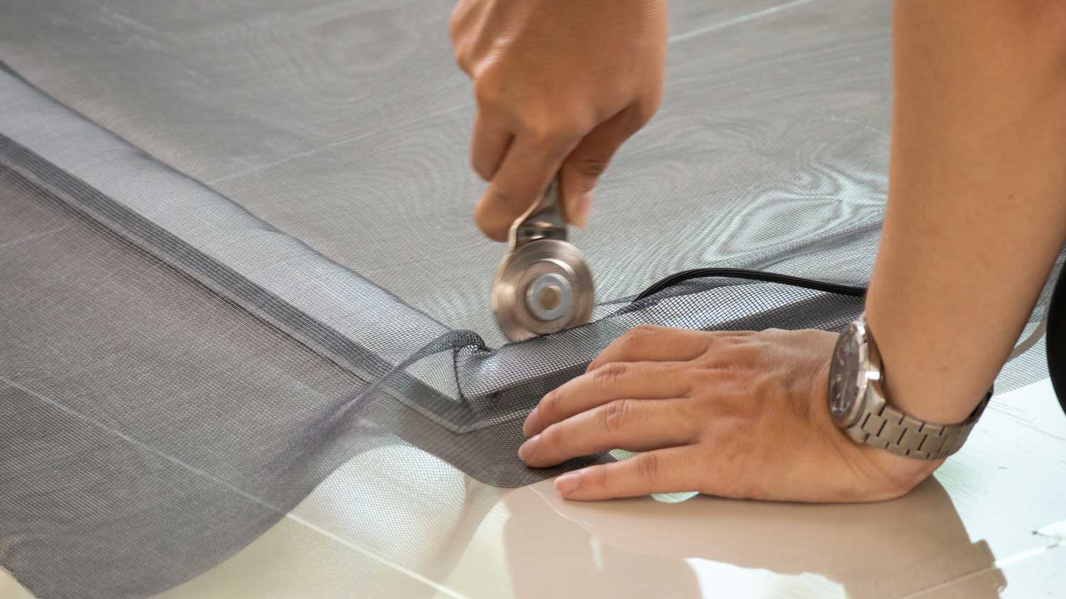 A man installing new screen door