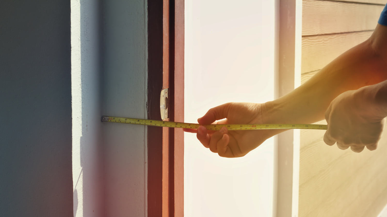 man measuring the width of front door