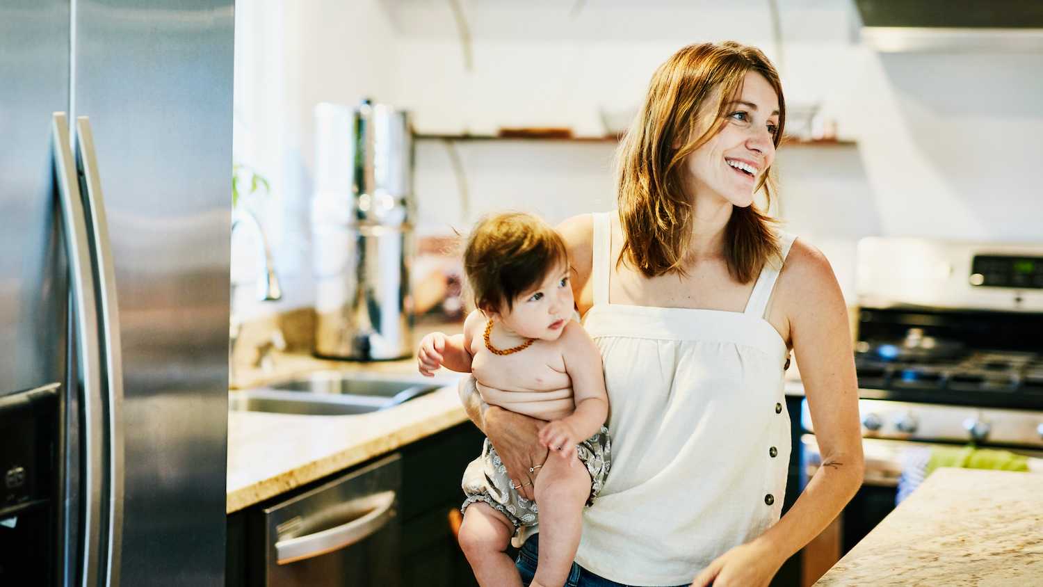 mother holding baby in kitchen