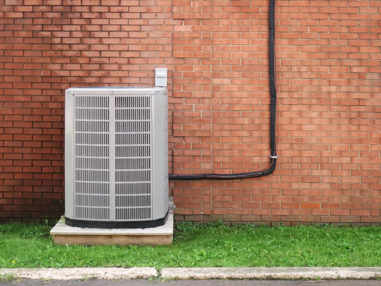 hvac air conditioner in front of brick wall