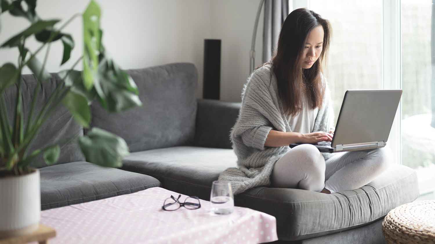 Woman sitting on the couch using her laptop