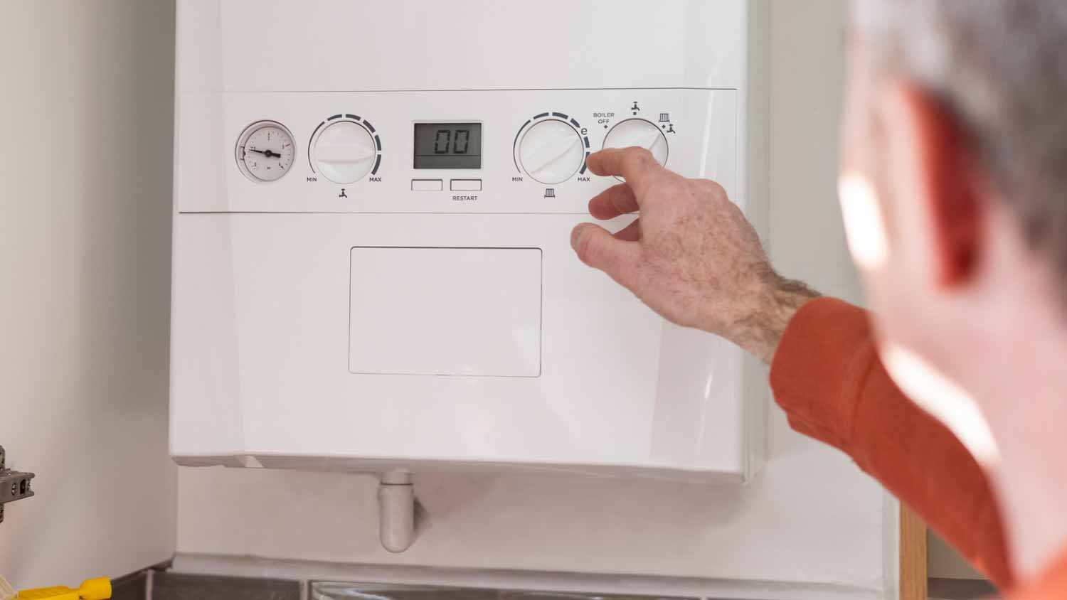 Man adjusting boiler