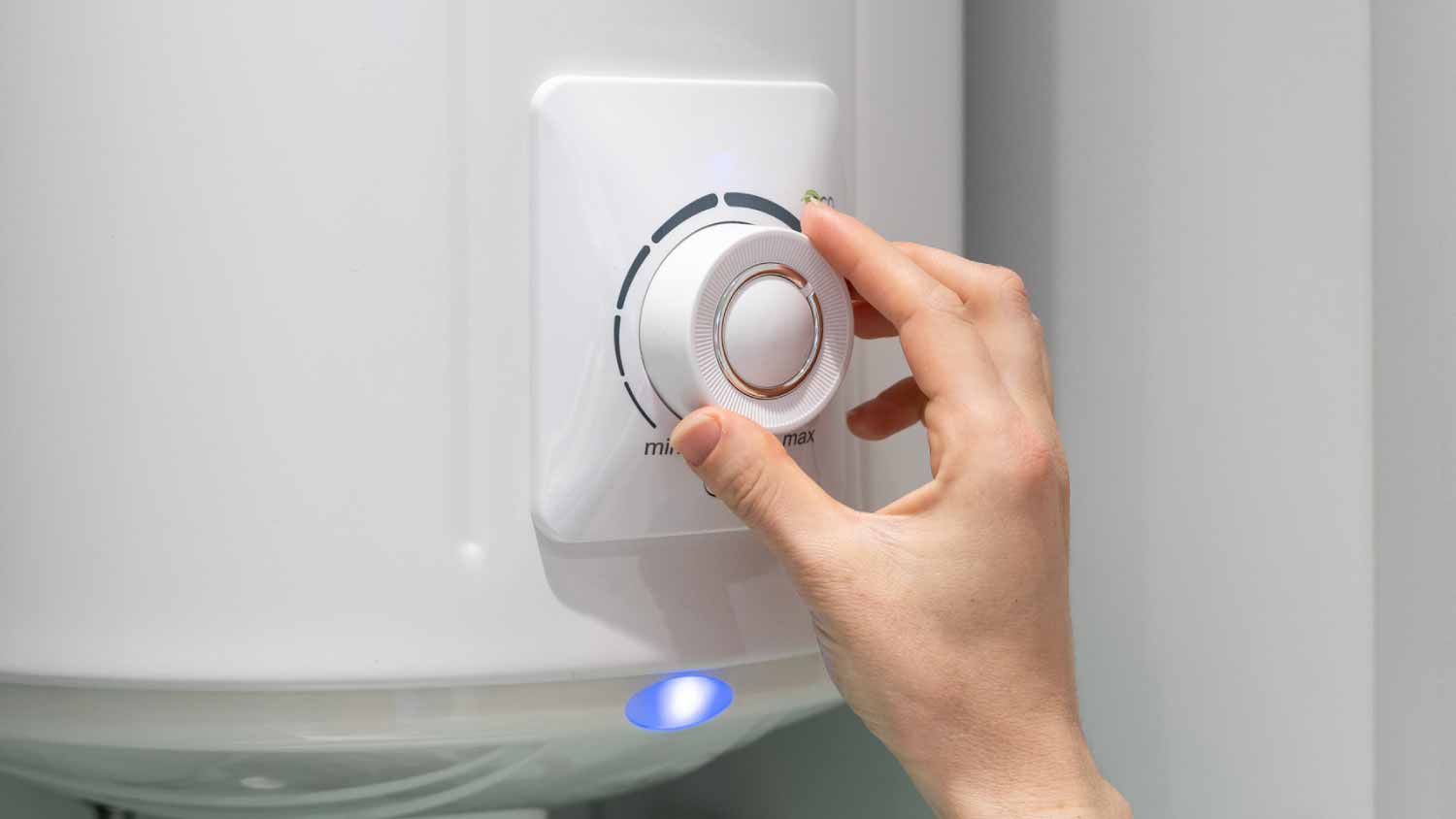 Woman setting temperature program on electric boiler