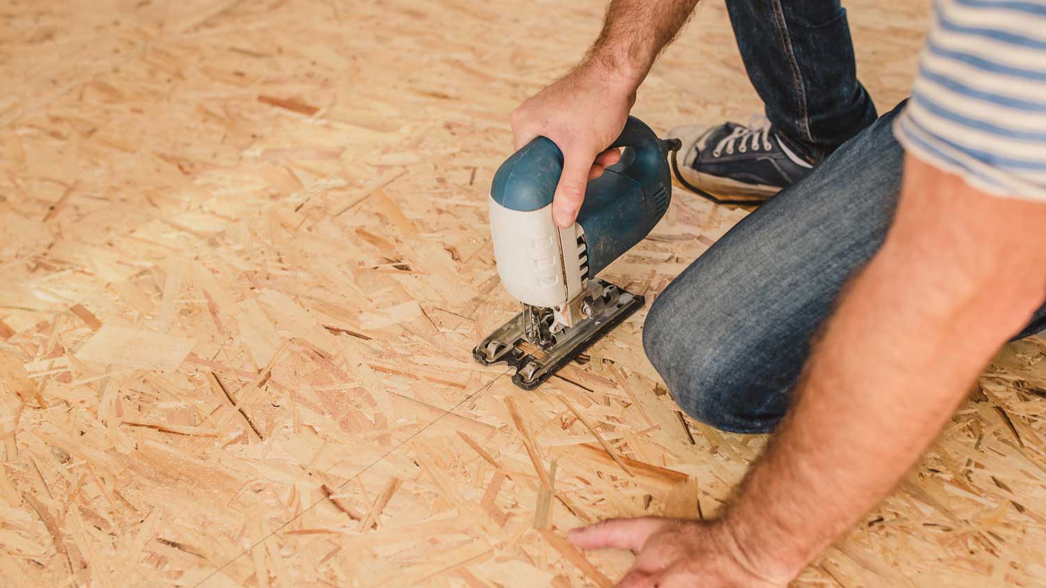 A person installing plywood for subfloor