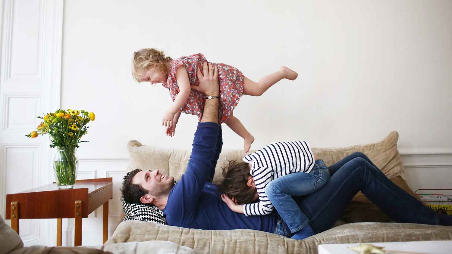 Dad playing with children on the sofa