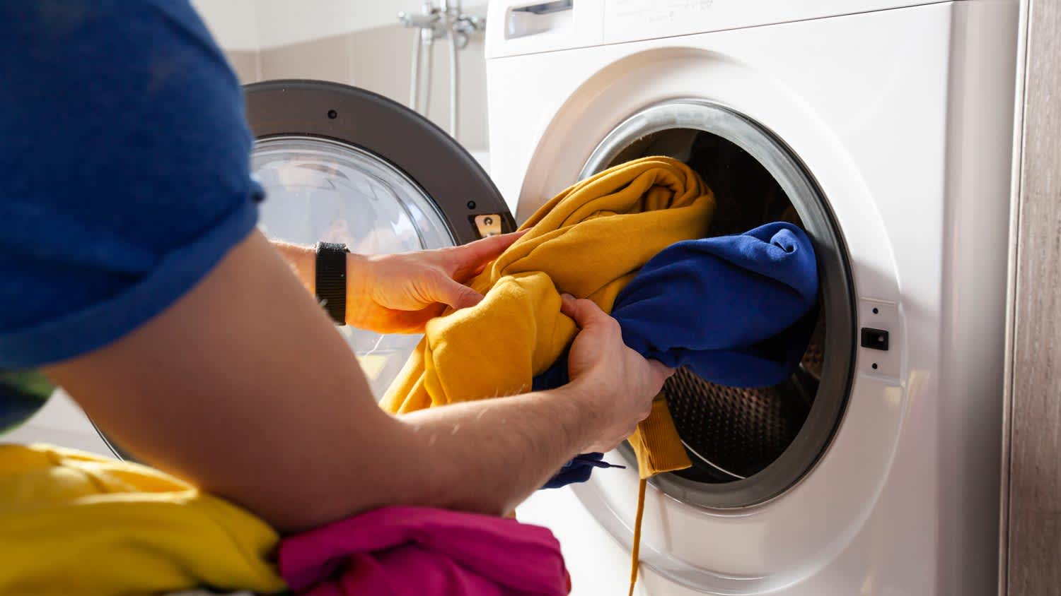 A man unloading clothes from a dryer
