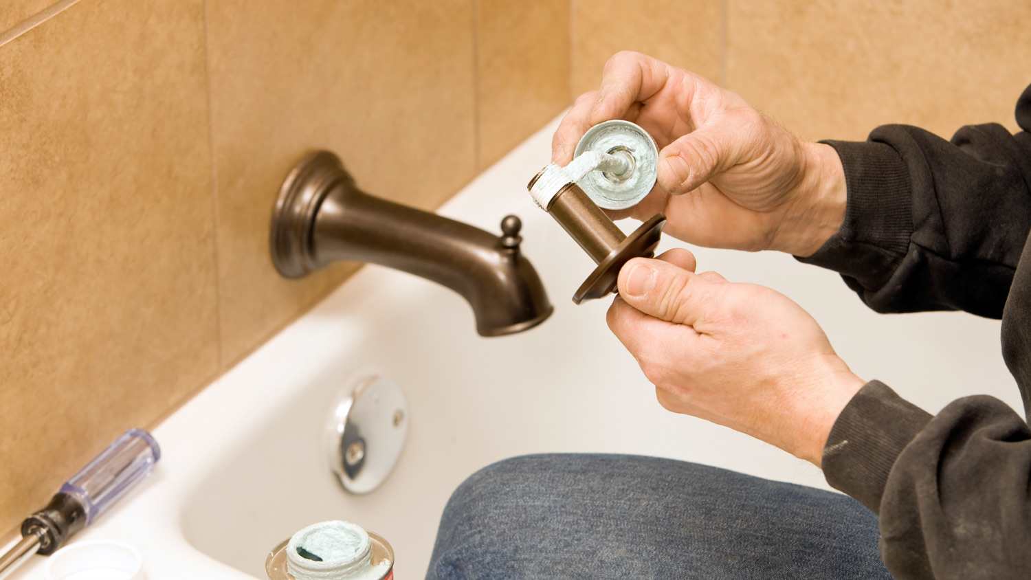 Plumber applying tape to pipe.