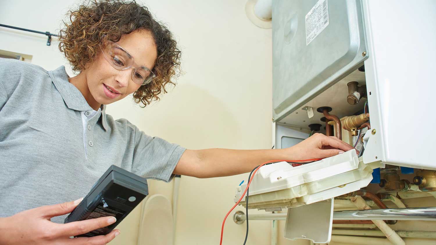A plumber inspecting an electric water heater