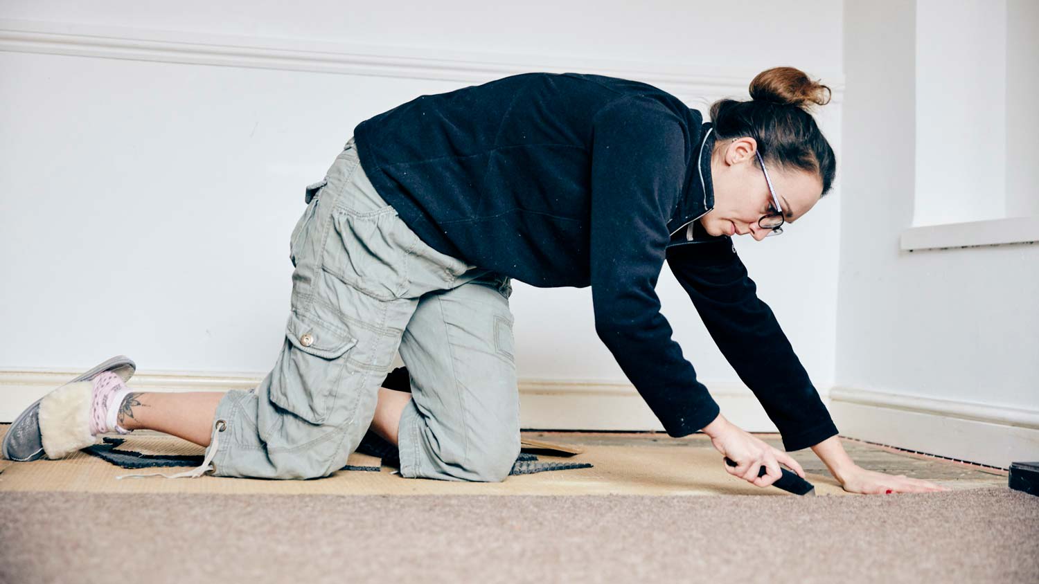 A woman cutting with a knife a problematic carpet area