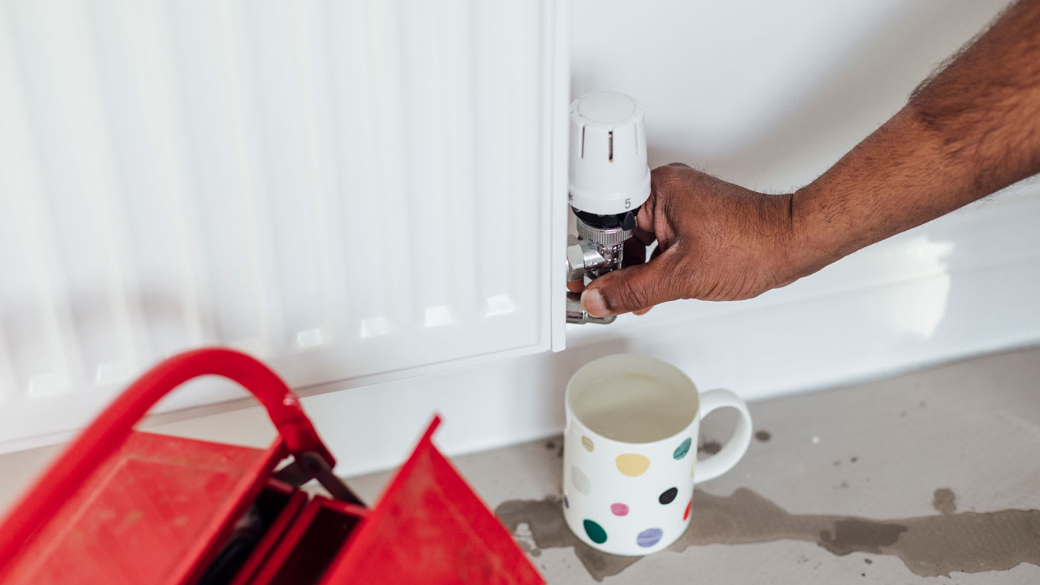 A person bleeding a baseboard heater